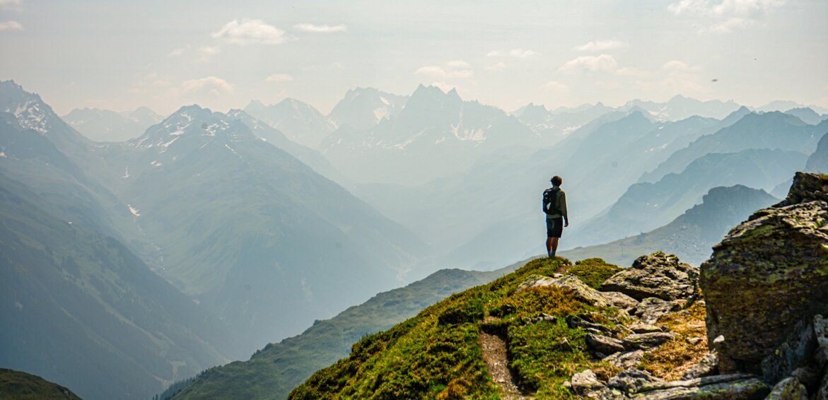 Ein Wanderer steht am Panoramaweg Zamang und genießt die Aussicht beim Wandern in der Silvretta Montafon. | © Silvretta Montafon - Vanessa Strauch