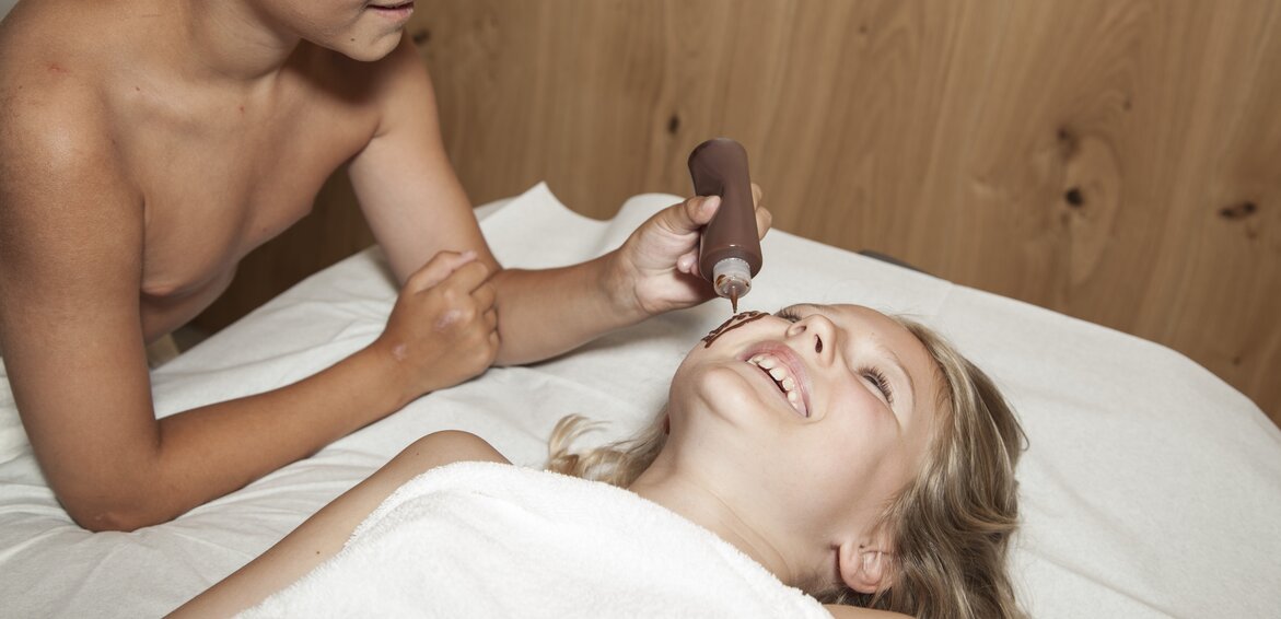 Ein Mädchen und ein Junge haben Spaß mit Schokolade bei ihrer Schokoladenmassage | © Silvretta Montafon