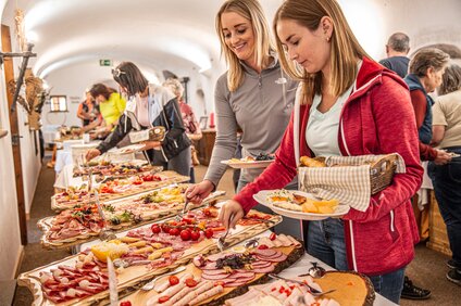 Bergfrühstück Winter - Silvretta Montafon | © Silvretta Montafon - Vanessa Strauch Zwei Frauen bedienen sich am Frühstücksbuffet in der Nova Stoba in der Silvretta Montafon. | © Silvretta Montafon - Vanessa Strauch