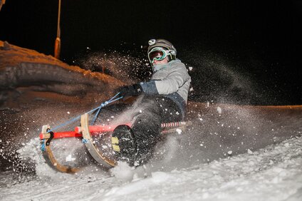 Nachtrodeln Garfrescha - Silvretta Montafon | © Silvretta Montafon - Marcel Mehrling Eine Person beim Nachtrodeln im Schnee. | © Silvretta Montafon - Marcel Mehrling