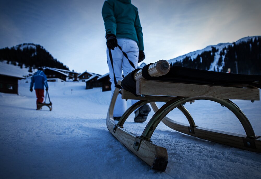 Nachtrodeln - Silvretta Montafon | © Silvretta Montafon - Daniel Zangerl Eine Frau zieht ihren Rodel über den Schnee zur Abfahrt der Nachtrodelbahn Garfrescha in der Silvretta Montafon | © Silvretta Montafon - Daniel Zangerl