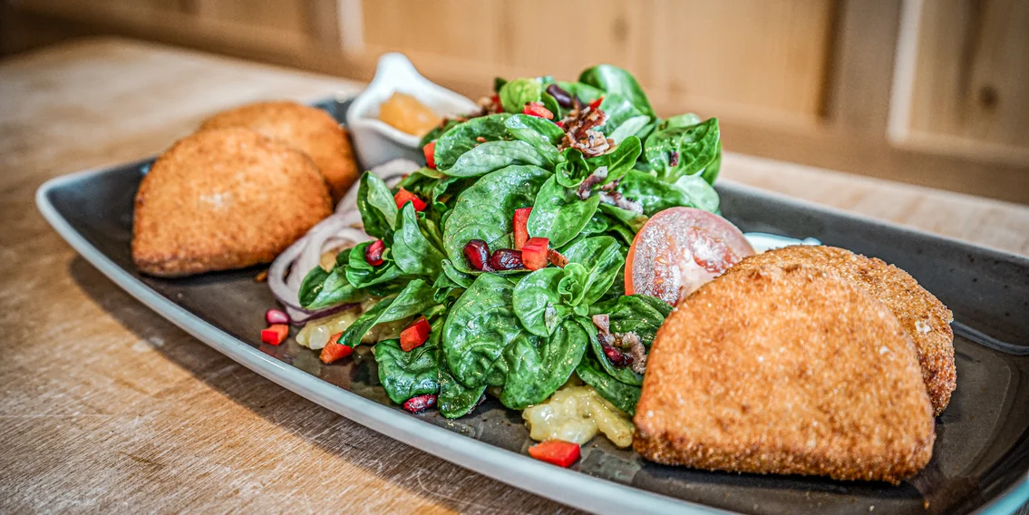 Ein Teller mit gebackenen Kässpätzli und Salat in der Nova Stoba. | © Silvretta Montafon - Vanessa Strauch