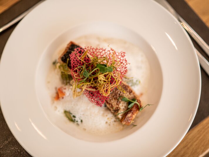 Fischgericht im Simons - Silvretta Montafon | © Silvretta Montafon - Mara Baues Ein Teller mit einem Fischgericht im Simons Alpenbrasserie im Sporthotel Silvretta Montafon. | © Silvretta Montafon - Mara Baues