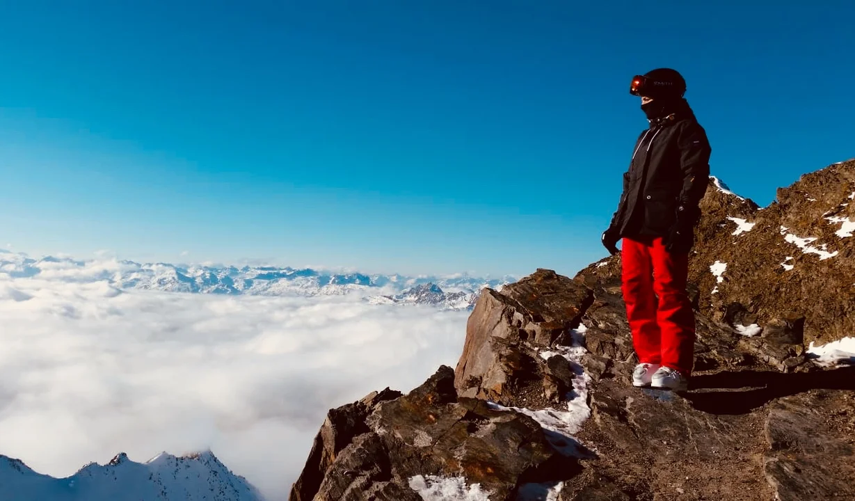 Eine Frau steht in Skiausrüstung auf einem Felsen im Skigebiet Silvretta Montafon. | © Luisa Idler - Silvretta Montafon