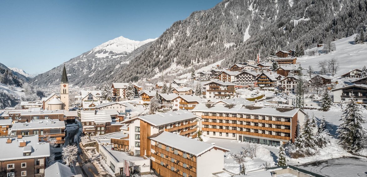 Das Sporthotel Silvretta Montafon schneebedeckt im Vordergrund mit weißen Bergen im Hintergrund | © Silvretta Montafon - blateral