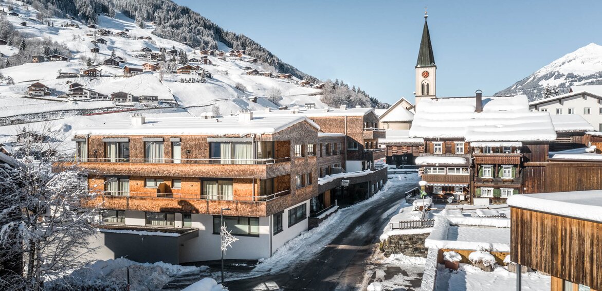 Blick auf die Sporthotel Chalets, die Stoba 7 und die Ortskirche in Gaschurn im Winter | © Silvretta Montafon - blateral